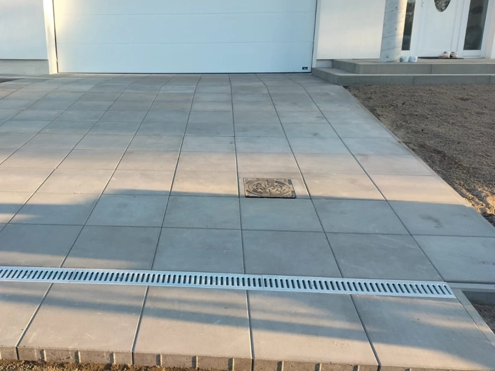 Układanie kostki brukowej z odwodnieniem liniowym przy garażu