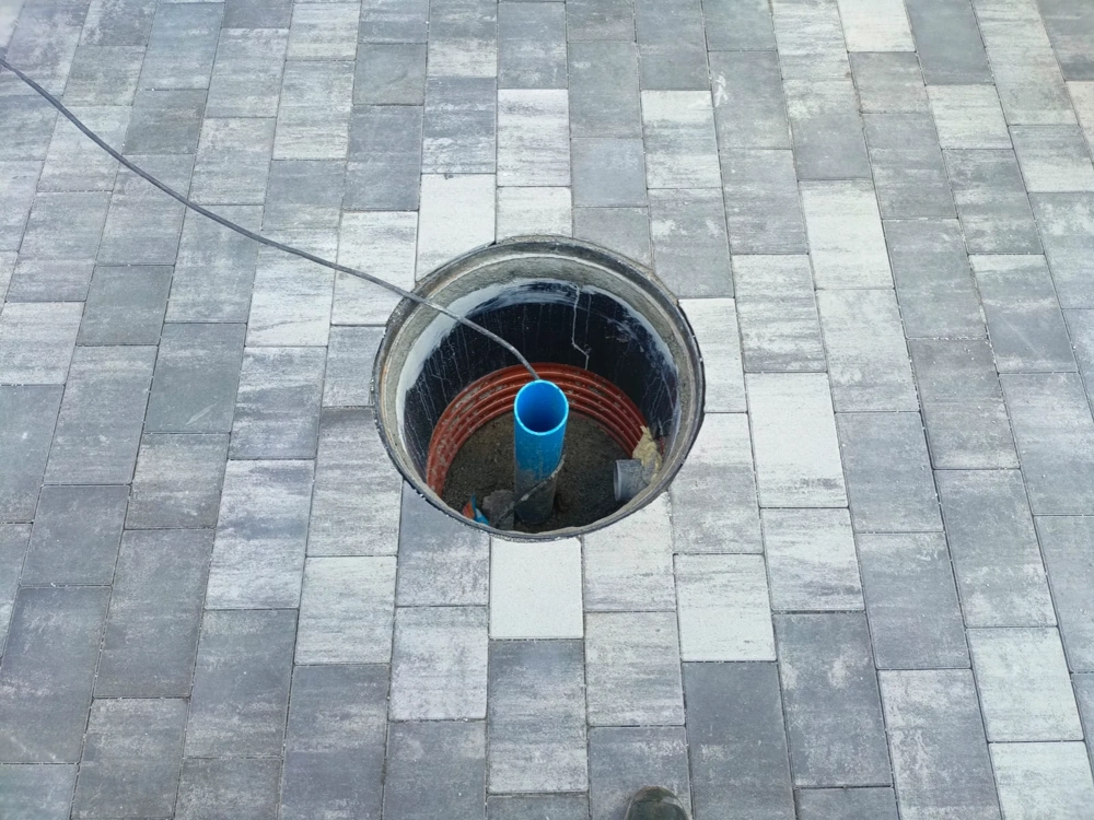 Studnie – okrągły otwór z rurą PCV w nawierzchni z kostki brukowej