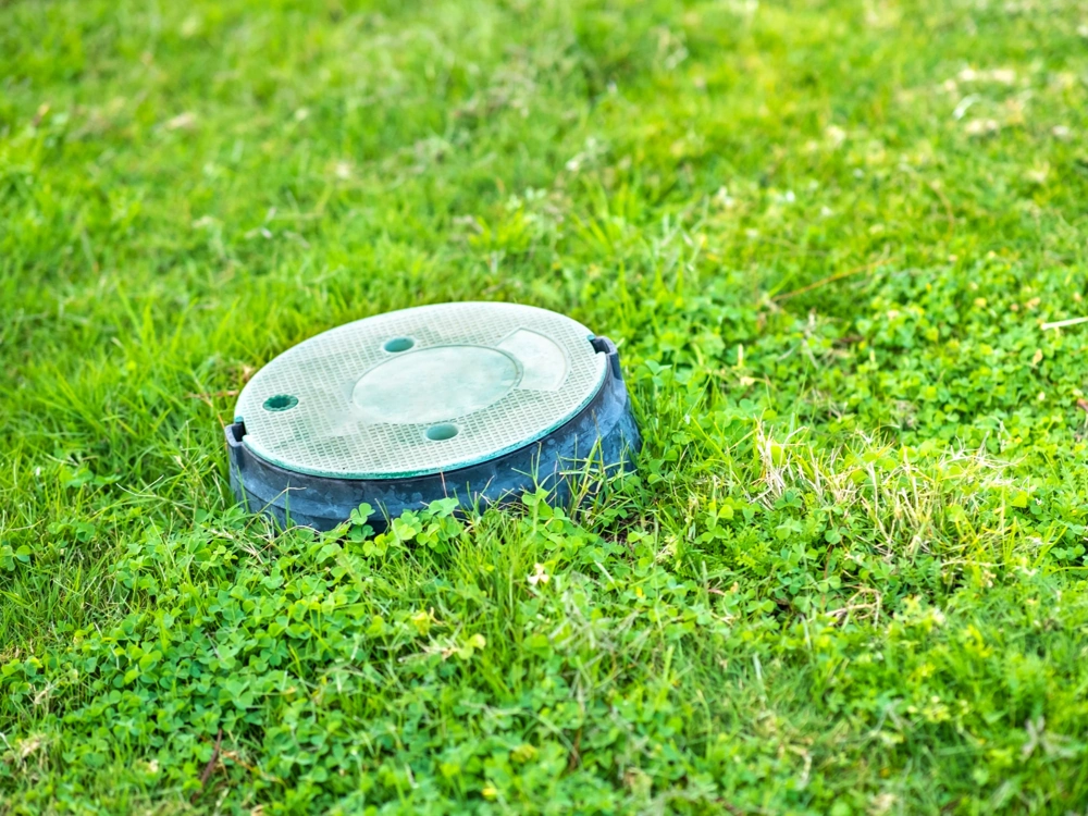 Drenaż – pokrywa rewizyjna studzienki drenarskiej na trawniku
