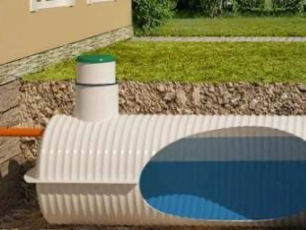 Montowany podziemny zbiornik na deszczówkę z widocznym przyłączem i przekrojem ukazującym wodę