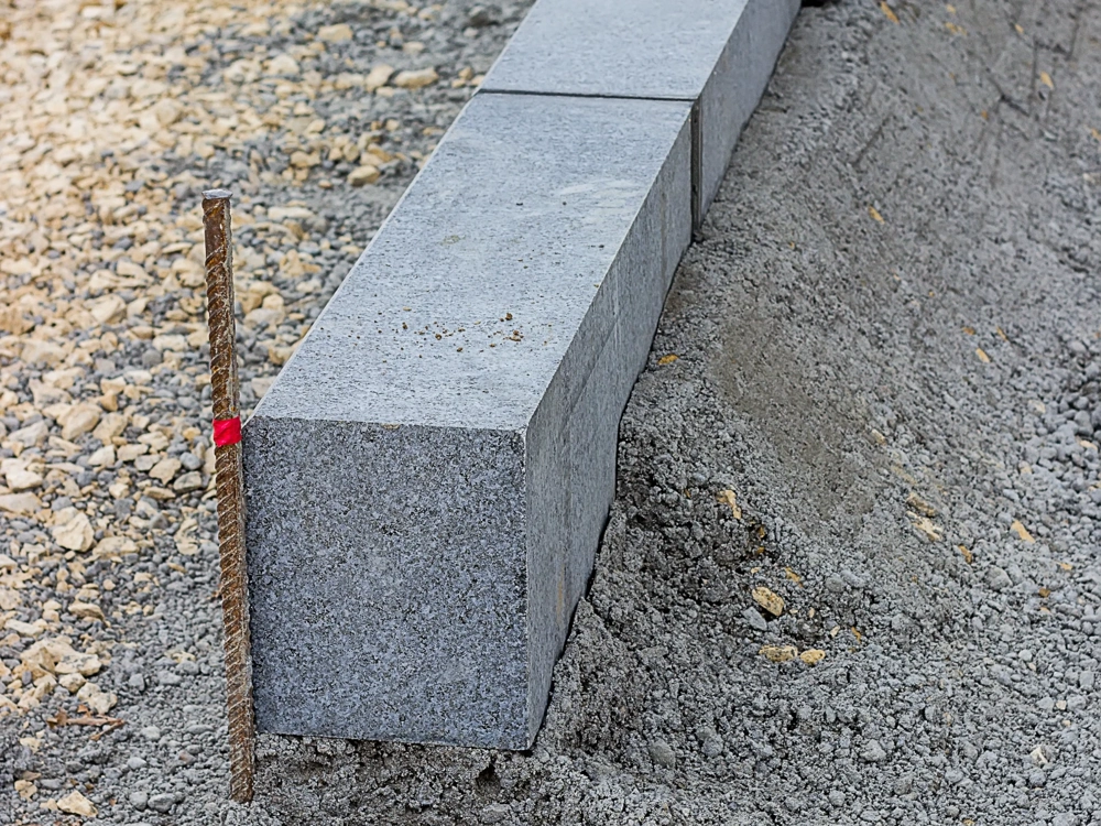 Krawężniki betonowe osadzone na podłożu z kruszywa i wyrównanym terenie